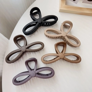 Set of five large matte butterfly hair claws in diverse earth tones on white background