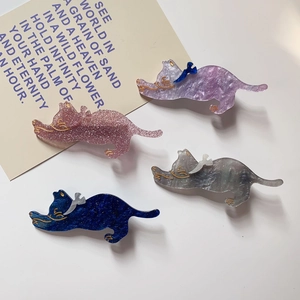Detail of four cute acetate cat hair clips in purple, pink, grey, and navy blue with bows
