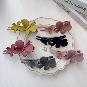 Lot de 6 barrettes papillon mates aux tons terreux sur un plateau blanc