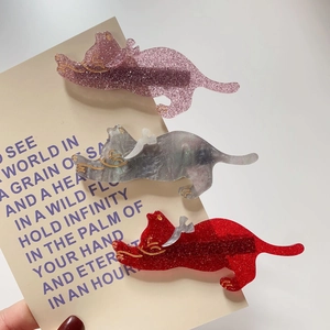 Detailed close-up of cute cat hair clips in pink, grey marble, and red glitter finish