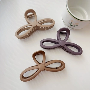 Detailed close-up of matte butterfly claw clips in earth tones and smooth metal spring design