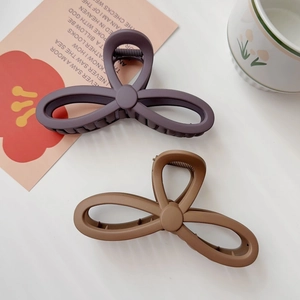 Matte finish large bow-shaped hair claw clips in dark purple and light brown colors
