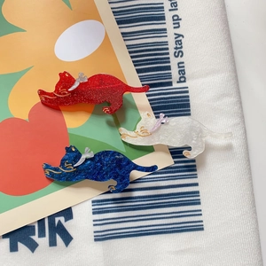 Close-up of three cute glitter cat hair clips in red, white, and blue with bows