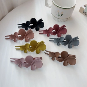 Détail de pinces à cheveux fleurs multicolores avec une finition mate élégante
