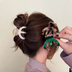 Elegant large acetate claw clips for women in pearl white, tortoiseshell, and emerald green