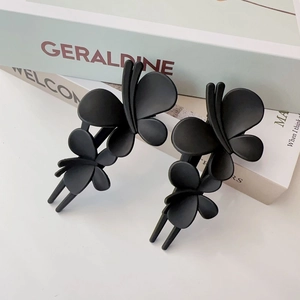 Gros plan de deux pinces à cheveux papillon noir mat sur des livres décoratifs