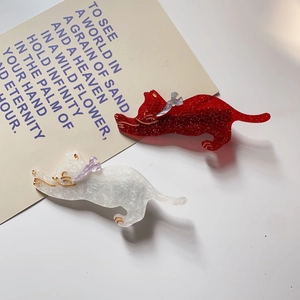 Detail of red and white glitter resin cat hair clips with decorative small bows