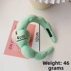 Detail view of mint green plush braided headband with handmade tag and 46g weight specification