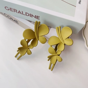 Vue macro de pinces à cheveux papillon jaunes mates sur des livres de décoration épurés