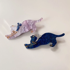 Close-up of cute cat-shaped acetate hair clips with marble texture and bird details
