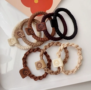 High elastic braided hair ties in neutral tones with smiley face buckle detail