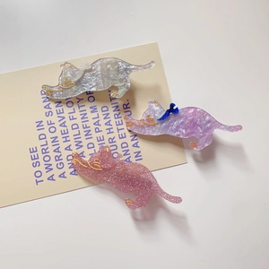Detailed view of three cat-shaped hair clips in pearl white, purple, and glitter pink