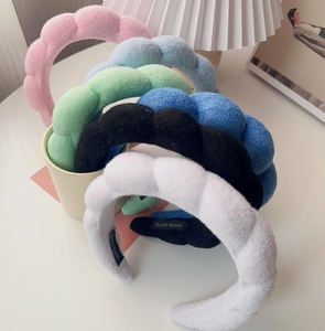 Detail of plush sponge headbands in various colors showing soft texture and handmade quality