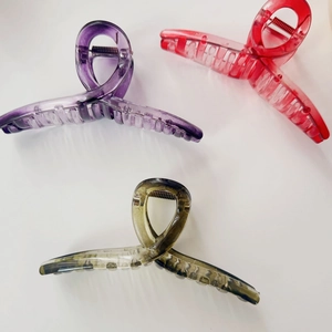 Three translucent hair claw clips in purple, red, and taupe with strong metal springs
