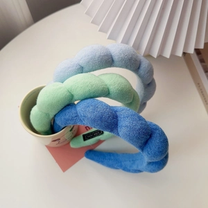Close-up of blue padded sponge headbands with soft plush texture in a ceramic cup