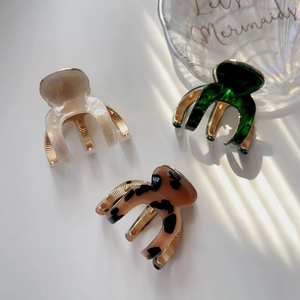 Close-up of marble, agate, and leopard print acetate hair claws with gold metal clips