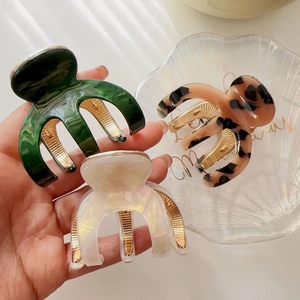 Detail of acetate shark hair claws in dark green, leopard print and pearl white