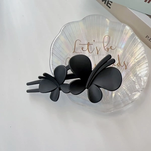 Détail de la pince à cheveux papillon noir mat avec une finition givrée lisse