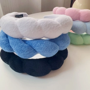 Detail of woven braided sponge headband showing soft plush texture and handmade label