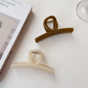 Dettaglio di mollette per capelli verde oliva e bianco crema in stile minimalista