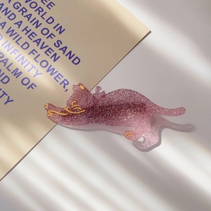 Detailed close-up of a pink glitter resin cat hair clip with gold accents and fine shimmer