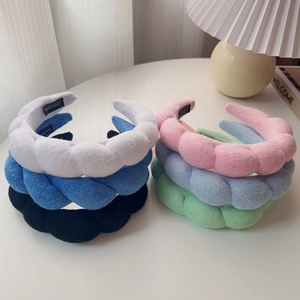 Detail of colorful braided sponge headbands with soft knit texture and handmade label