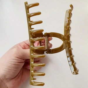 Dettaglio della grande pinza per capelli ambra con molla in metallo per capelli folti