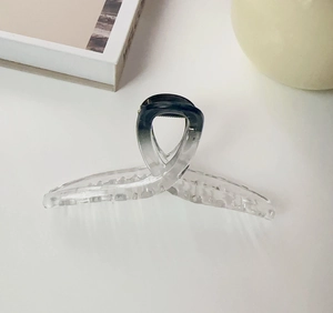 Detail of elegant gradient grey acrylic shark hair claw clip with cross-loop design