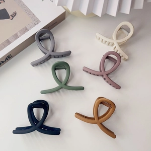 Set of six matte Morandi color hair claw clips with cross design on white background