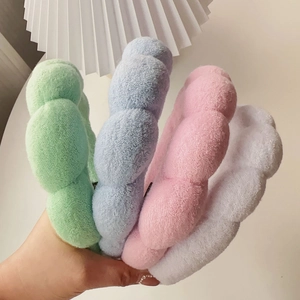 Close-up of thick sponge headbands in pastel green blue pink and white soft terry fabric