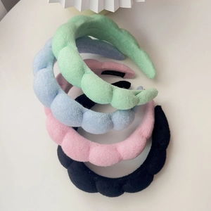 Detail of twisted sponge headbands in pastel green, blue, pink and black velvet colors