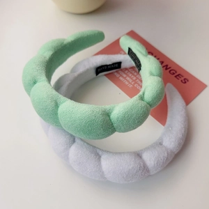 Detail of mint green and grey padded braided headbands with handmade woven labels