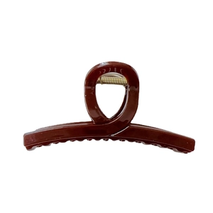 Grande molletta per capelli marrone scuro lucida con molla dorata su sfondo bianco