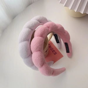 Detail of plush handmade padded headbands in purple and pink with woven hand made label