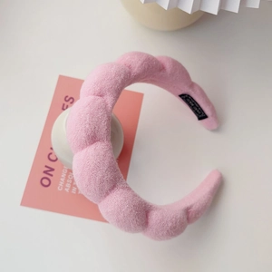 Detailed view of pink twisted sponge headband with soft towel fabric and handmade label