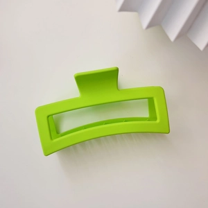 Close-up of a matte neon green rectangular hair claw clip for thick hair styling