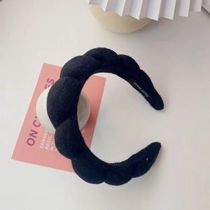 Detail showing high crown thick sponge headband with matte suede texture and handmade label