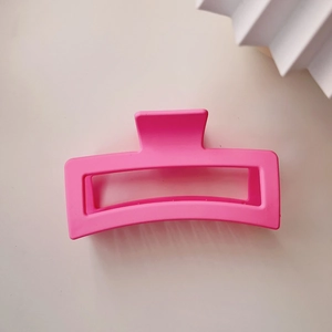 Close-up of a large pink matte square hair claw clip with a hollow rectangular design
