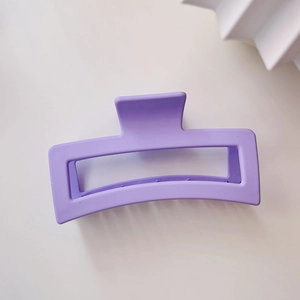 Detail of a 13cm matte purple square claw clip with a hollow design on a white background