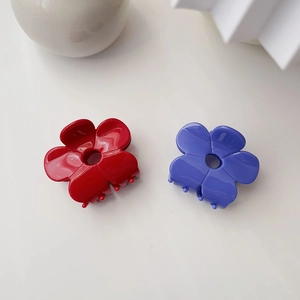 Detail of red and purple flower hair claws made of glossy acetate material