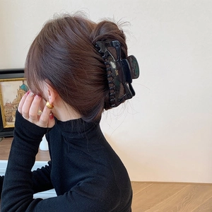 Grande pince à cheveux noire brillante en acétate avec détails dorés pour femme