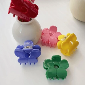 Macro detail of multi-color acetate flower hair claws with durable metal spring mechanism