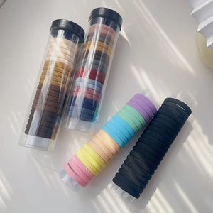 Detail von hochelastischen nahtlosen Haargummis in verschiedenen Farben und Zylinderverpackung