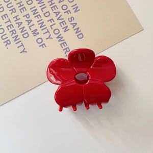 Close-up of bright red floral hair claw clip showing glossy resin petals and sturdy spring