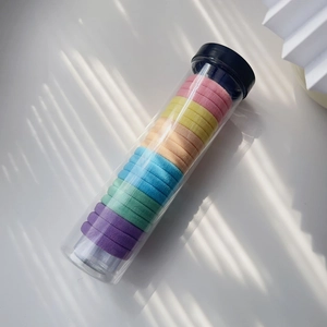Regenbogen-Haargummis in einer klaren Dose mit natürlichem Licht und Schattenspielen