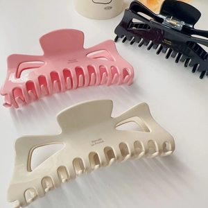 Détail de pinces à cheveux en résine brillante crème et rose avec texte Barrette La France