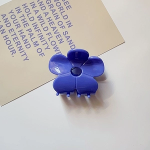 Detailed view of a purple flower hair claw clip made of glossy acetate material