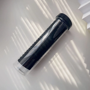 Minimalistisches Set aus schwarzen nahtlosen Haargummis in einem transparenten Vorratsglas