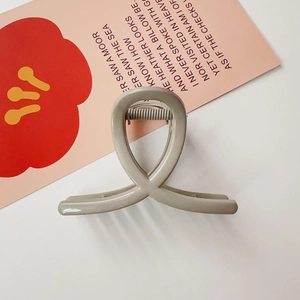 Détail d'une pince à cheveux croisée gris mat avec ressort métallique haute élasticité