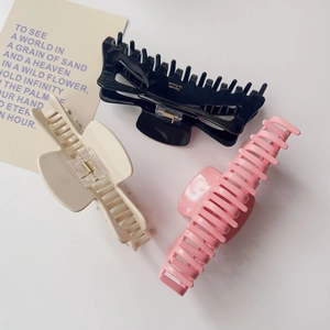 Lot de trois grandes pinces à cheveux en acétate noir, beige et rose au fini brillant